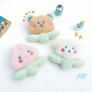 Detail of plush bear, flower, and cloud pins with neat embroidery on white background