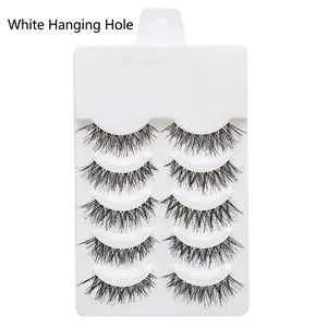 Detailed view of 5 pairs of crisscross black false eyelashes on a white display board