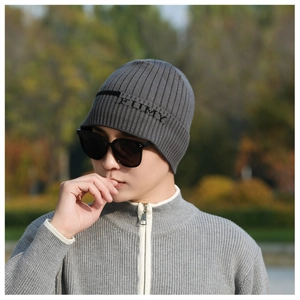 Nahaufnahme der grauen Rippstrick-Beanie mit schwarzem Schriftzug und Texturdetails