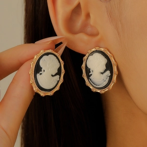 Vintage oval cameo earrings with gold lace frame and black relief on female model