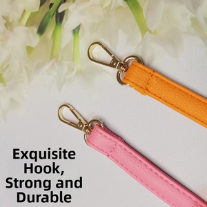Détails des bandoulières orange et rose avec mousquetons métalliques dorés fins