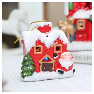 Detail of red ceramic Christmas house ornament with snow roof and blue LED light