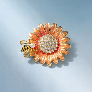Detailed view of enamel sunflower brooch with central crystals and a small pearl bee