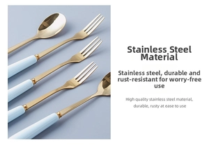 Detail of light blue ceramic handle and golden stainless steel fork and spoon set