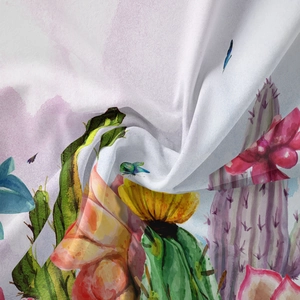 Detail of bohemian tapestry featuring watercolor cactus and floral prints on soft fabric
