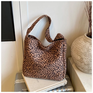 Close-up of leopard print shoulder bag on a suitcase showing velvet texture and wide strap