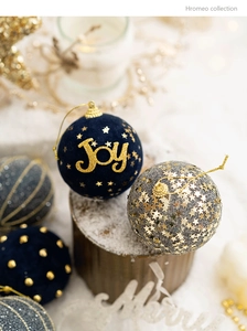 Detail of blue velvet Christmas ball with golden Joy text and glitter stars decor
