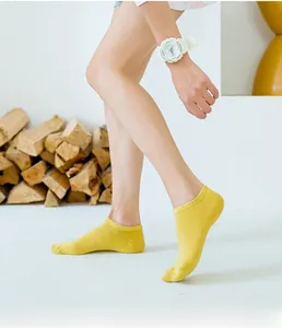 Detail of bright yellow cotton low-cut socks showing soft knit texture and ribbed cuff