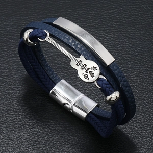 Detailed close-up of dark blue braided leather bracelet with guitar pendant and magnetic clasp
