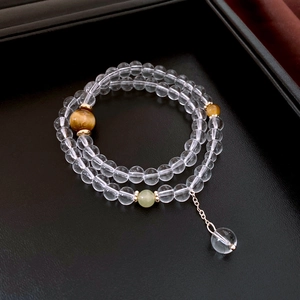 Close-up of beaded bracelet with crystal glass spheres and tiger eye stone accents