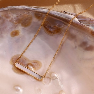 Détail du collier barre plaqué or 18 carats avec insert en nacre sur une huître perlière