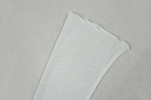 Close-up of white sheer mesh fabric featuring ruffled lettuce edges and pleated texture