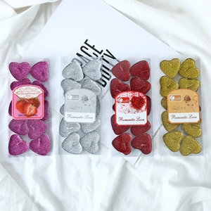 Detail of heart-shaped glitter tea light candles in purple, silver, red, and gold colors