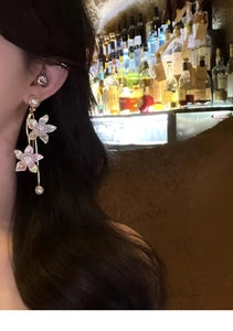 Close-up of elegant flower tassel earrings with white pearls and sparkling crystals