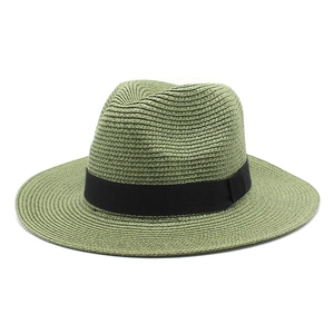 Close-up of woven paper straw texture and black ribbon detail on a green sun hat