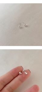 Close-up of mini S925 sterling silver heart stud earrings held to show delicate size