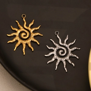 Macro view of gold and silver sun pendants with spiral pattern and hammered texture