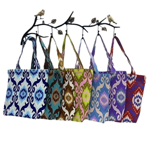 Traditional Ikat pattern tote bags in six colors hanging on a decorative branch stand