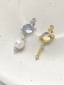 Detail of 14k gold-plated planet pendants with zircon stars and shimmering opal stones