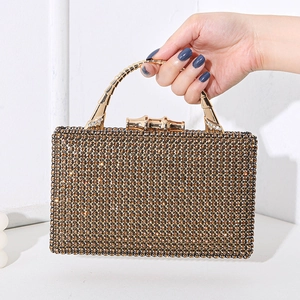 Elegant gold evening clutch bag with sparkling rhinestones and a metal bamboo handle