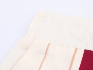 Gros plan détaillé du tissu rayé beige et rouge foncé avec coutures de haute qualité