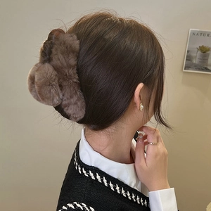 Brown faux fur claw clip for women, large plush hair accessory shown on model's hair