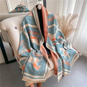 Macro detail of high-quality cashmere-like scarf with blue and orange equestrian patterns