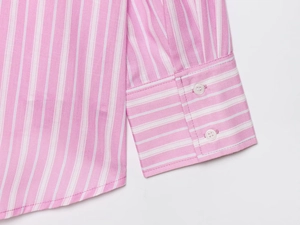 Detail of pink and white striped shirt showing fine fabric texture and button stitching