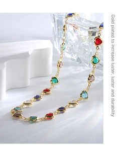 Detail of colorful heart-cut cubic zirconia gems on a gold-plated necklace chain