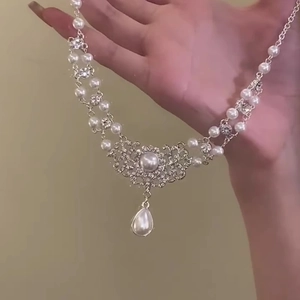 Detailed view of Baroque pearl necklace with sparkling rhinestones and drop pendant