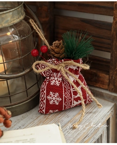 Detail of red linen Christmas pouch with pine cones, berries and snowflake print