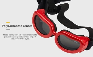 Detail of red pet goggles featuring UV protective polycarbonate lenses and adjustable strap