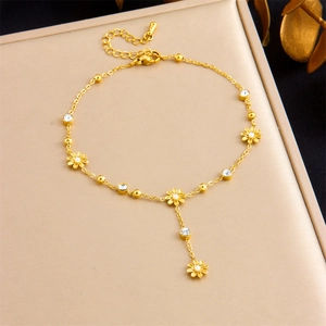 Détail de la chevillère en acier inoxydable doré avec breloques marguerites et strass brillants