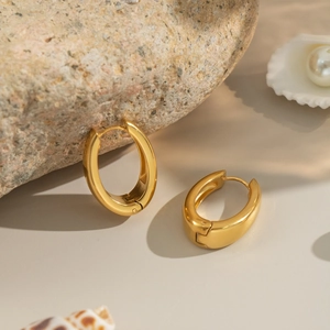 Minimalist U-shaped 18K gold-plated stainless steel hoop earrings on natural rock