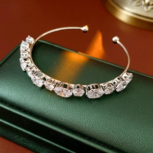 Détail macro d'un bracelet jonc argenté à double rangée avec fleurs en zircons brillants