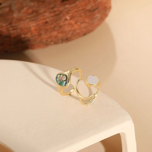 Detail of gold rings with colorful abalone shell and white mother of pearl inlay