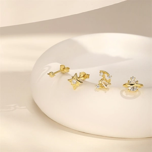 Macro detail of S925 silver gold earrings set with star and moon zircon elements