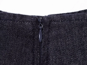 Macro detail of high-waist indigo denim jeans featuring a seamless zipper and stitching