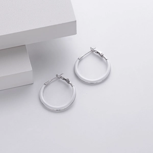 Macro detail of silver 925 sterling silver hoop earrings with white inner ring circles