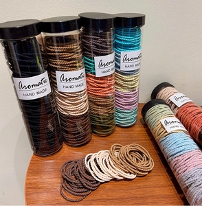 Close-up of assorted colorful elastic woven hair ties in transparent storage jars