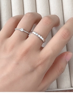 Close-up of S925 sterling silver couple rings set featuring solitaire and disc band on hand