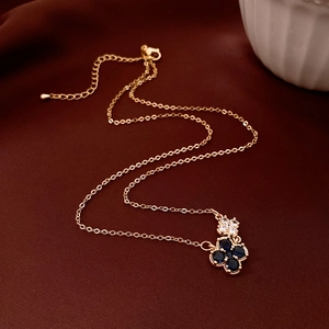 Gros plan du pendentif fleur en or 18k avec pierres bleues sur tissu en soie