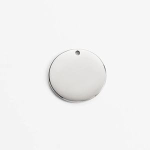 Close-up of a silver stainless steel round pendant with pre-drilled hole for DIY jewelry