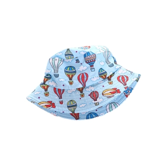 Dettaglio cappello sole per bambini celeste con stampe colorate di mongolfiere e nuvole