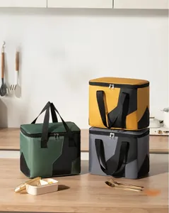 Three-color insulated lunch bags on wooden kitchen counter for outdoor picnic and work