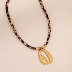 Detail of leopard print woven rope necklace with polished golden shell pendant charm