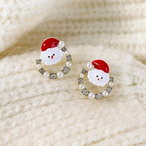 Macro view of Santa Claus earrings with pearls, crystals, and red enamel details