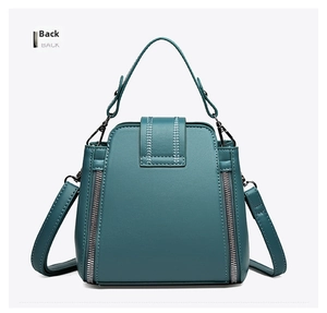 Detailed back view of dark teal leather handbag featuring white contrast stitching