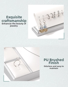 Detail of white PU leather jewelry display set with brushed silver base for earrings and rings