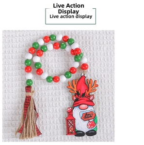 Detail of Christmas wooden bead garland with Santa dwarf pendant and plaid tassel